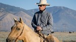 Cowboy on horseback with mountain range in the background